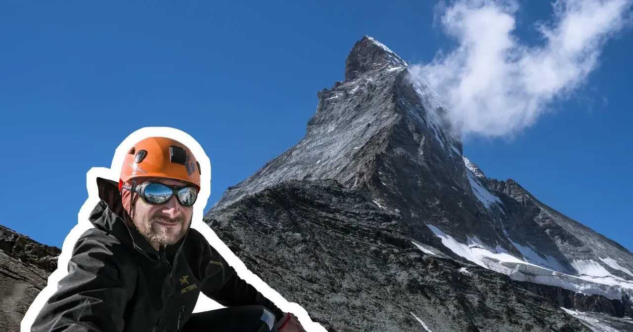 Uśmiechnięty alpinista w kasku i goglach na tle majestatycznego Matterhornu. To jego wejście na Matterhorn, cel zdobyty!