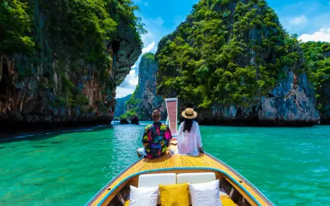 Para w łodzi podziwia turkusową wodę i skaliste wyspy. Idealna pogoda na Phuket w grudniu.