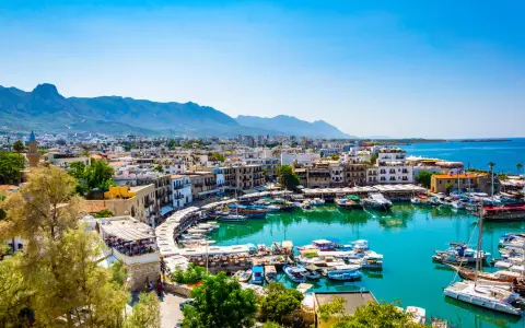 Kyrenia, Cypr, gdzie najcieplej, z malowniczym portem pełnym łodzi i górami w tle.