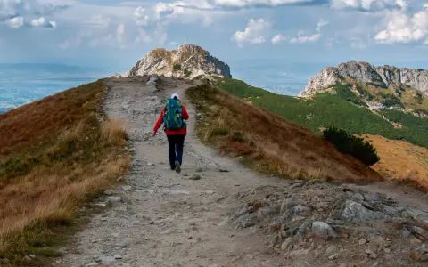 Wędrowiec idzie ścieżką ku czerwonym wierchom z Kuźnic.