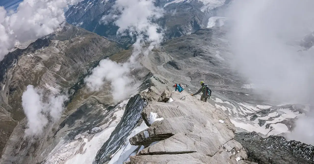 Wspinacze na skalistej grani, zbliżający się do szczytu. Widok zapiera dech w piersiach, to wejście na Matterhorn.